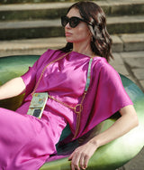 Die Dame in Rosa präsentiert unser Iphone 13 Pro handytasche aus feinem Leder mit Blumendruck und Gold Kette - Eine Exklusiv design von Mia Min Milano