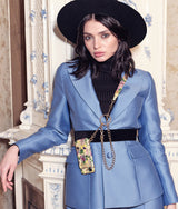 Eine schöne Frau, die Mia Min Milano`s exklusiv Iphone 13 Pro Hanyhülle aus Leder in Gelb mit einem einzigartigen design präsentiert.